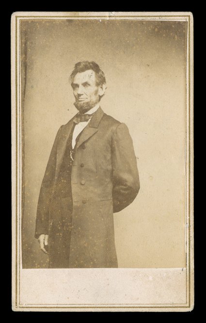 [Lincoln, Abraham] Choice date carte-de-visite Photograph by Matthew B. Brady, a three-quarter-length pose of Abraham Lincoln standing with his left arm behind his back. Printed
by E.A. Anthony of New York. With two-cent Andrew Jackson postag